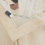 Close-up on the tempered glass surface of the handcrafted cane side table. Its tempered glass top provides an easy-to-clean surface, making it ideal for everyday use. It also bounces light off, creating an open impression.
