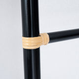 Close-up on the handcrafted black cane ladder, one of Nature Native's best-loved pieces. The bindings on each rung features natural rattan, creating a beautiful contrast with the black frame.