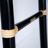 Close-up on the handcrafted black cane ladder, one of Nature Native's best-loved pieces. The bindings on each rung features natural rattan, creating a beautiful contrast with the black frame.