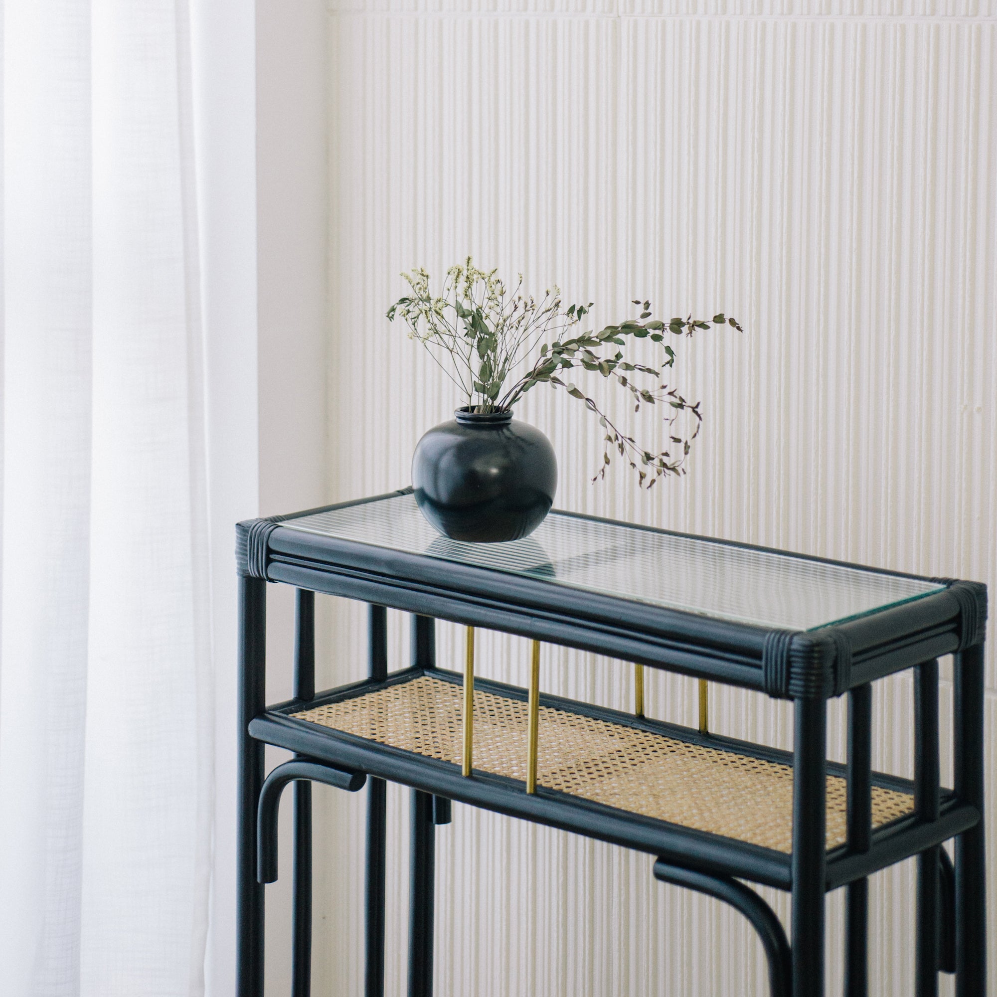 Minimalist black rattan console table with a sleek design and sturdy construction, perfect for adding functional elegance to any entryway or living space. Designed in Singapore, it features a balanced combination of form and function, offering ample surface space while maintaining a lightweight, airy aesthetic.