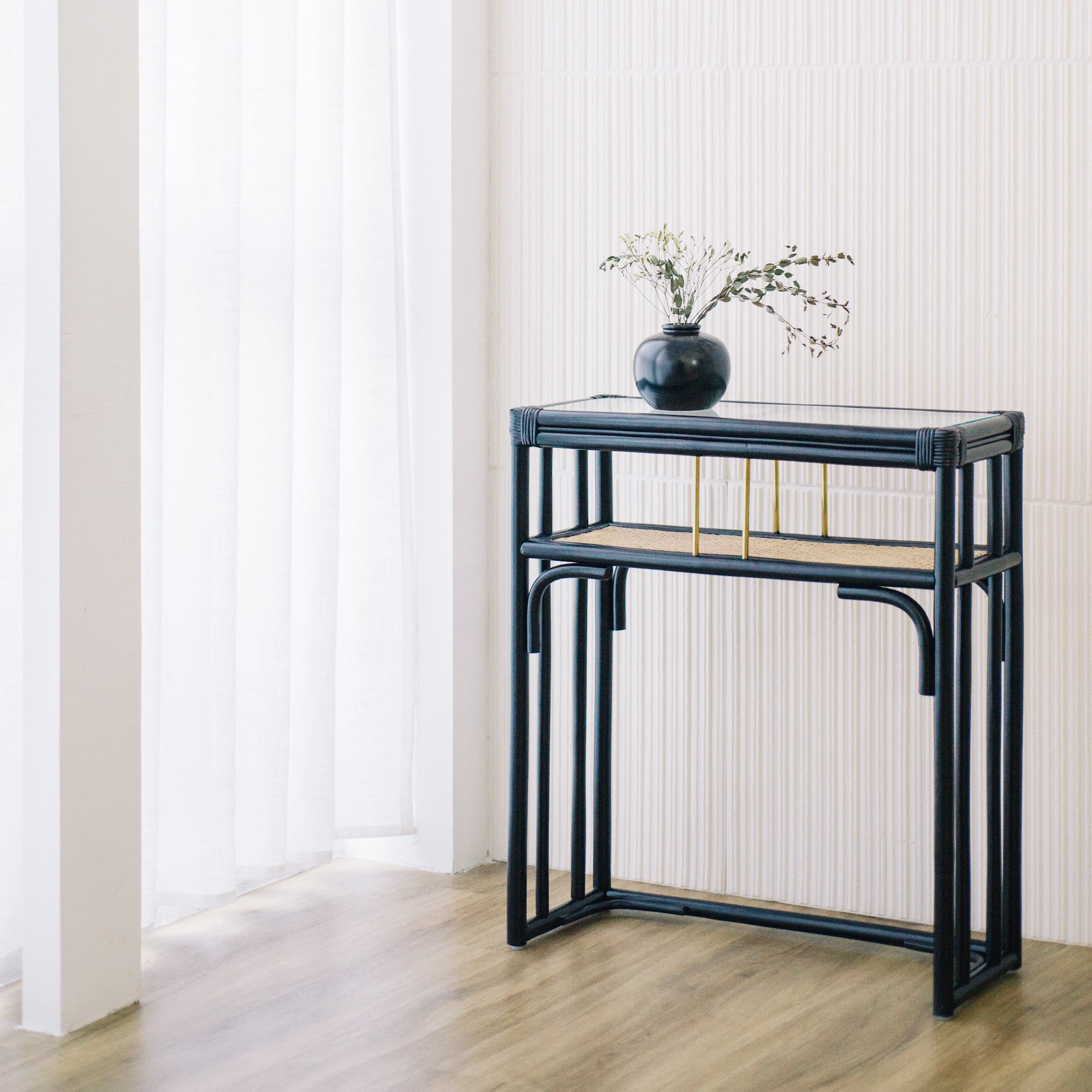 Minimalist black rattan console table with a sleek design and sturdy construction, perfect for adding functional elegance to any entryway or living space. Designed in Singapore, it features a balanced combination of form and function, offering ample surface space while maintaining a lightweight, airy aesthetic.