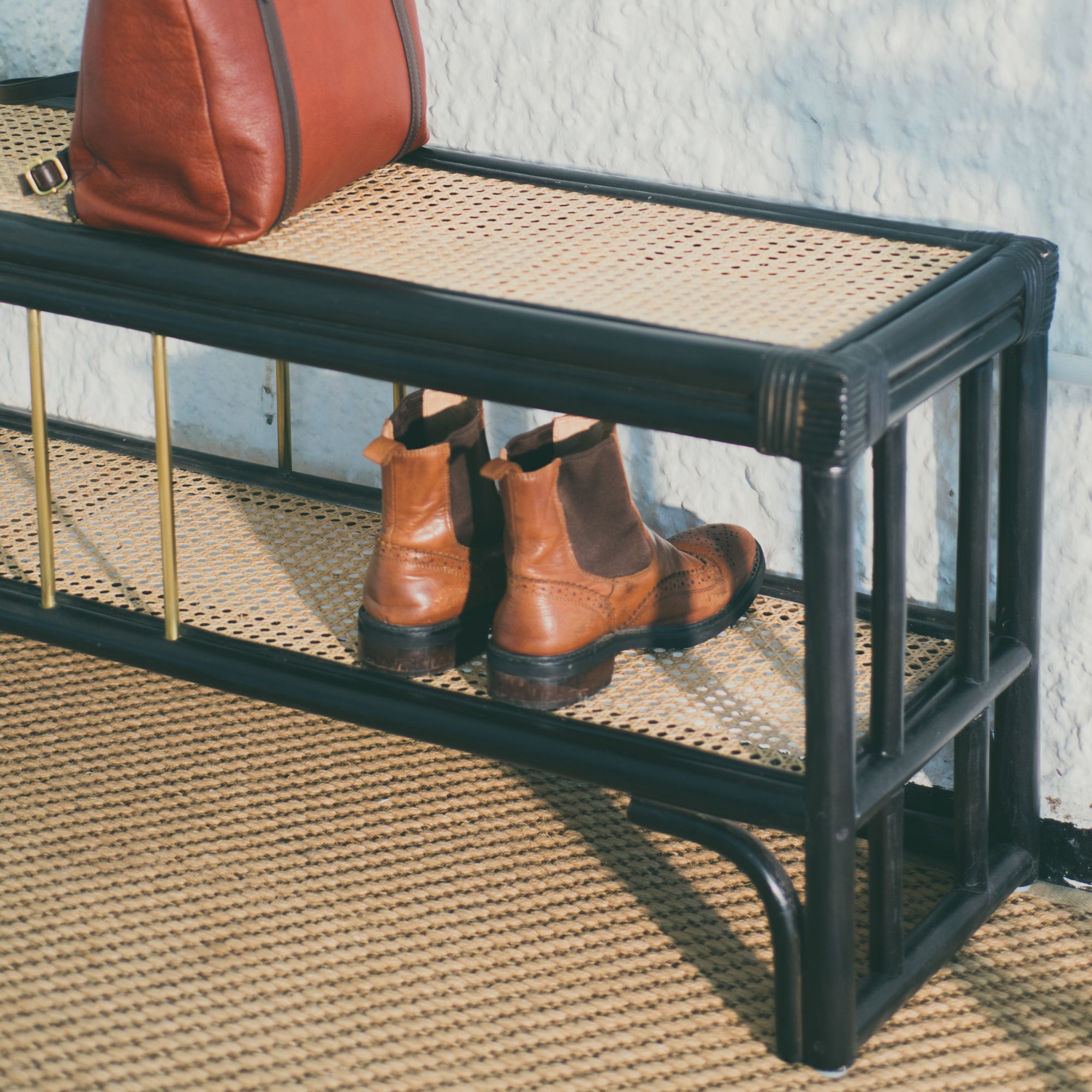 Black rattan shoe bench with an open-concept, double-layer design, offering ample storage for shoes and more. Designed in Singapore, it seamlessly blends natural elegance with functionality, perfect for modern entryways.