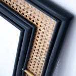 Black rattan mirror with a handcrafted frame, combining natural texture and modern design. Its sleek finish and minimalist aesthetic make it a versatile statement piece for any room. Designed in Singapore, it reflects timeless elegance with a touch of heritage charm.