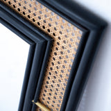 Black rattan mirror with a handcrafted frame, combining natural texture and modern design. Its sleek finish and minimalist aesthetic make it a versatile statement piece for any room. Designed in Singapore, it reflects timeless elegance with a touch of heritage charm.