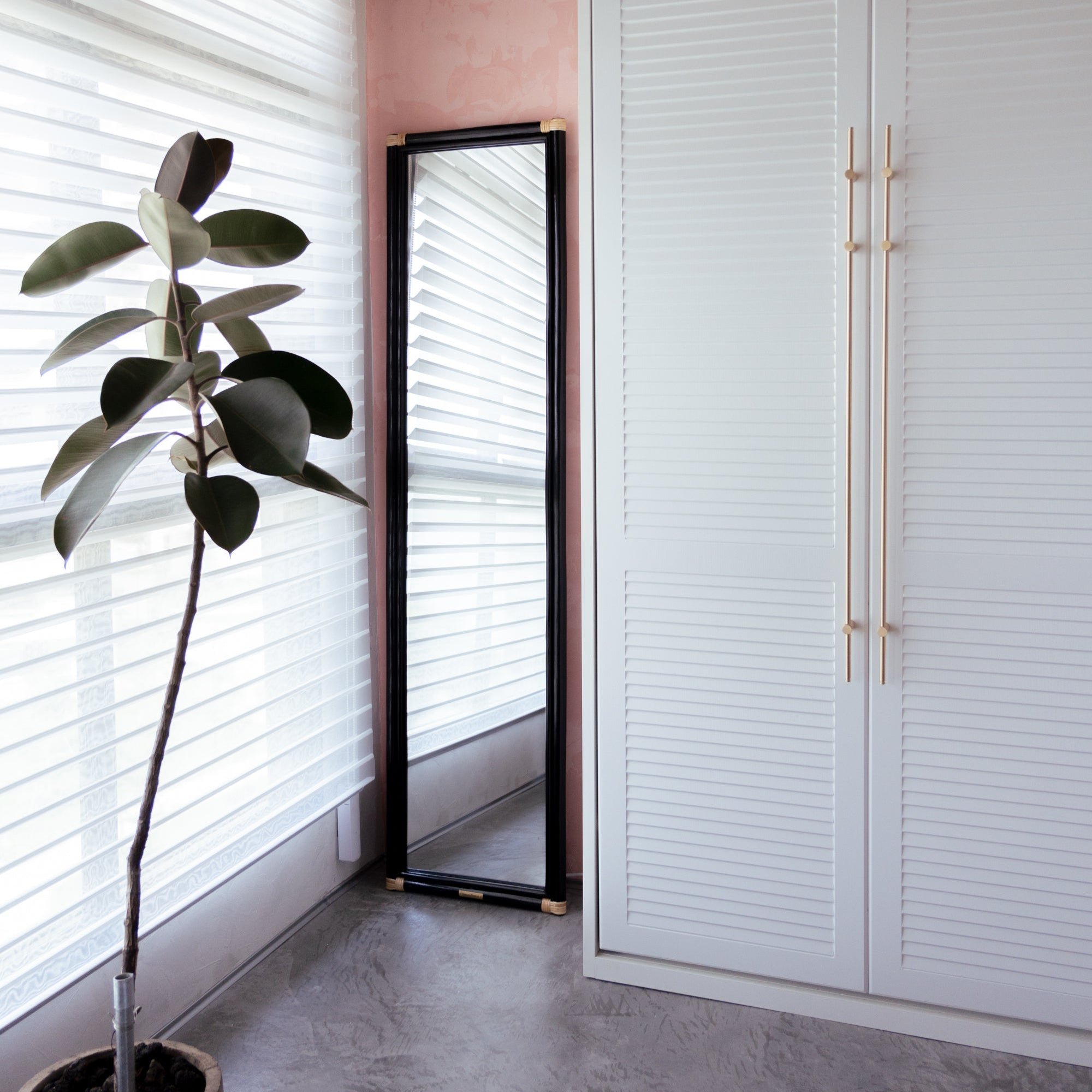 REI Floor Mirror in Black positioned to catch natural daylight in a bedroom